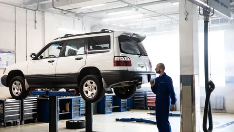 A car up on the ramps in a workshop.